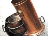 un grand vase en cuivre posé sur un plateau en métal