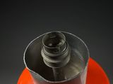 a red gas canister with a metal cap on top of it