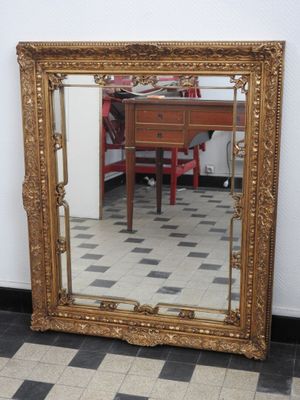 un grand miroir posé par terre à côté d'une table