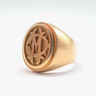 a close up of a gold signet ring with a man ' s initials on it