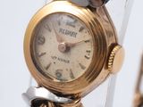 une montre-bracelet en or avec une chaîne autour d'elle