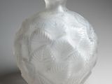 a white glass vase with a leaf pattern on it