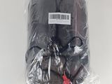 un sac noir contenant de la nourriture, emballé dans du plastique, posé sur une surface blanche