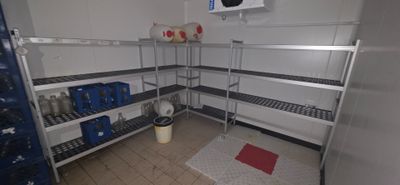 a picture of a room with a lot of shelves and a trash can