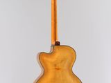 the back of an acoustic guitar hanging from a string