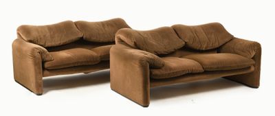 two brown couches sitting next to each other on a white surface