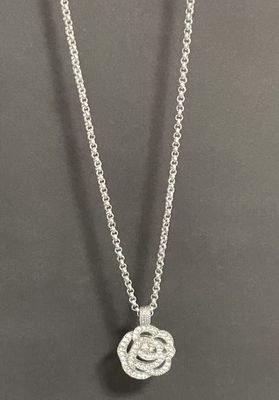 a white gold necklace with a diamond flower pendant on a chain
