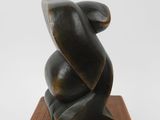 an image of a black sculpture on a wooden base