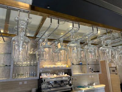 de nombreux verres à vin suspendus au plafond au-dessus du bar