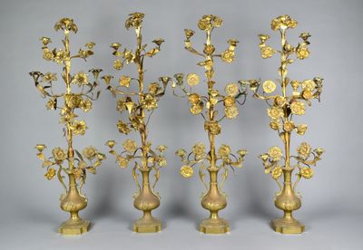 four gold colored vases with flowers in them