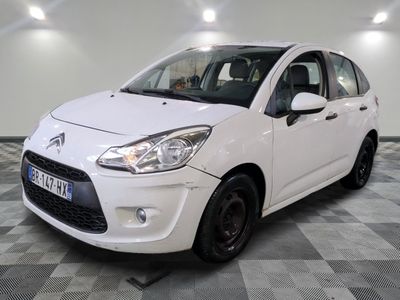 la petite voiture blanche est garée sur un sol en damier