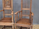 two wooden chairs sitting next to each other on a wooden floor