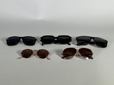 three pairs of sunglasses sitting on top of a white surface