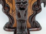 a wooden vase with a carved face on it