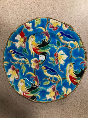 une image représentant une assiette bleue ornée d'oiseaux et de fleurs