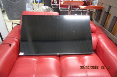 un ordinateur portable posé sur un canapé en cuir rouge