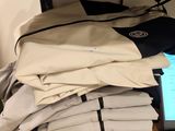 a laptop computer sitting on top of a pile of folded shirts