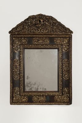 an ornate mirror with a wooden frame on a white wall