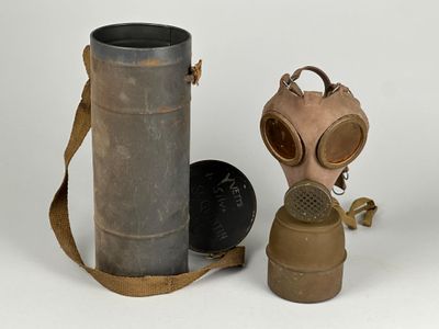 deux vieux masques à gaz et une cartouche sur fond blanc