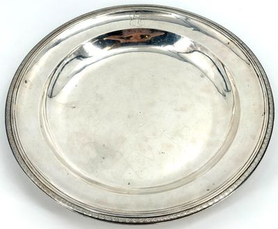 an antique silver plate on a white background with a brown handle