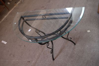 une table en verre avec une base en métal et un plateau en verre