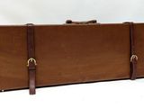 a brown suitcase that is sitting on a white surface