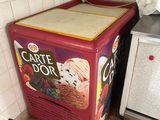 un réfrigérateur rouge sur lequel sont posées des glaces, dans une cuisine
