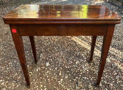 une vieille table en bois avec un bouton rouge sur le plateau
