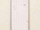 a white door with red paint on it in a room