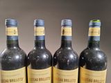 four bottles of wine are lined up on a table