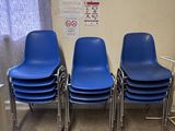 Quatre chaises bleues sont alignées contre un mur dans une salle d'attente