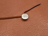 brown leather wallet with a silver coin on top of it