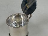 a silver cup with a spoon in it on a table