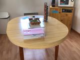 une table en bois sur laquelle est posé un livre, dans une pièce
