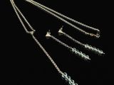 a close up of a necklace and earring on a black background