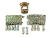two pieces of metal with green and gold designs on them