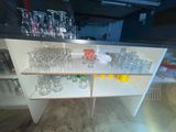 bottles and glasses on a shelf in a room with a lot of bottles