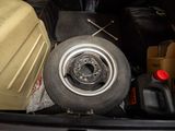 the back of a car with a tire and a wheel in the trunk