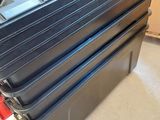 a stack of black plastic containers sitting on the floor