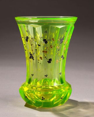 a green glass vase with black spots on it