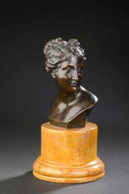 un buste en bronze représentant une femme, posé sur un socle