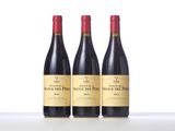 three bottles of red wine sitting on top of a table