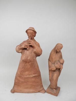deux figurines en argile représentant une femme et un homme debout l'un à côté de l'autre