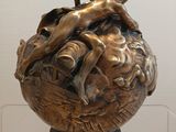 a bronze statue of a man and a woman on a globe