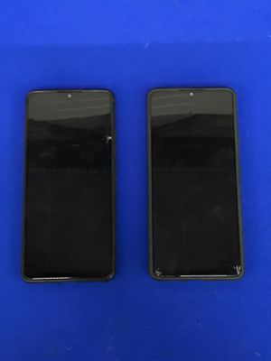 deux iPhones noirs posés l'un à côté de l'autre sur une surface bleue