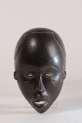 une image montrant un gros plan d'un masque noir sur une surface blanche