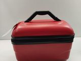 a red suitcase with a black handle on a white table