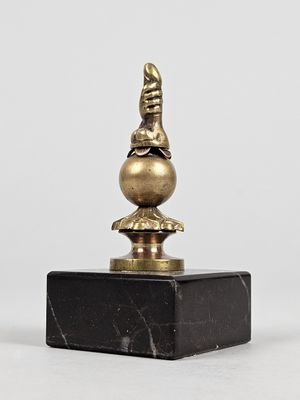 une figurine en laiton représentant un oiseau, posée sur un socle en marbre noir