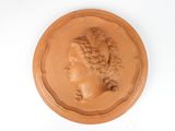 an image of a clay plaque with a woman ' s head on it