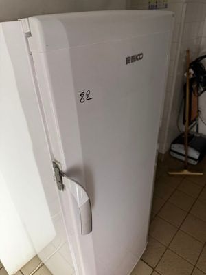 a white refrigerator in the corner of a kitchen